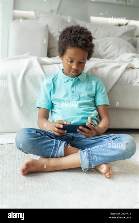 Child sitting cross-legged on the floor using mobile phone Stock Photo - Alamy