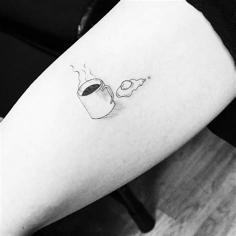 Coffee cup and fried egg tattoo on the right inner arm.