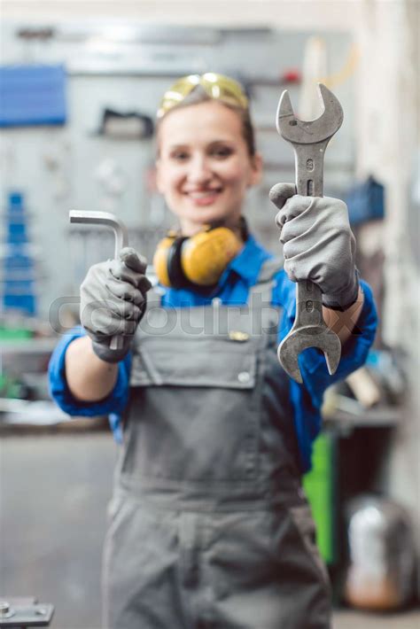 Woman mechanic showing tools to the camera | Stock image | Colourbox