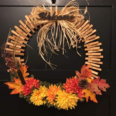 a wreath made out of sticks and fake flowers on the front door to celebrate fall