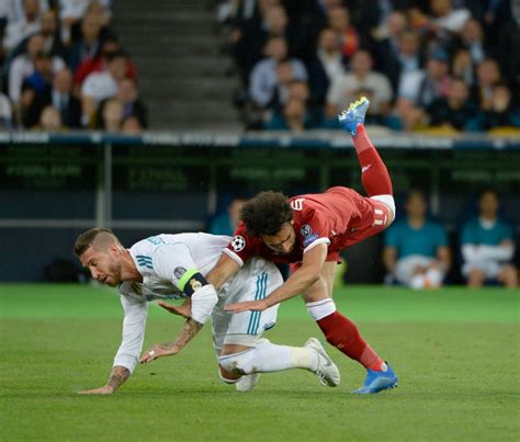 KIEV, UKRAINE - MAY 26: Mohamed Salah of Liverpool has his arm held by Sergio Ramos (left) of ...