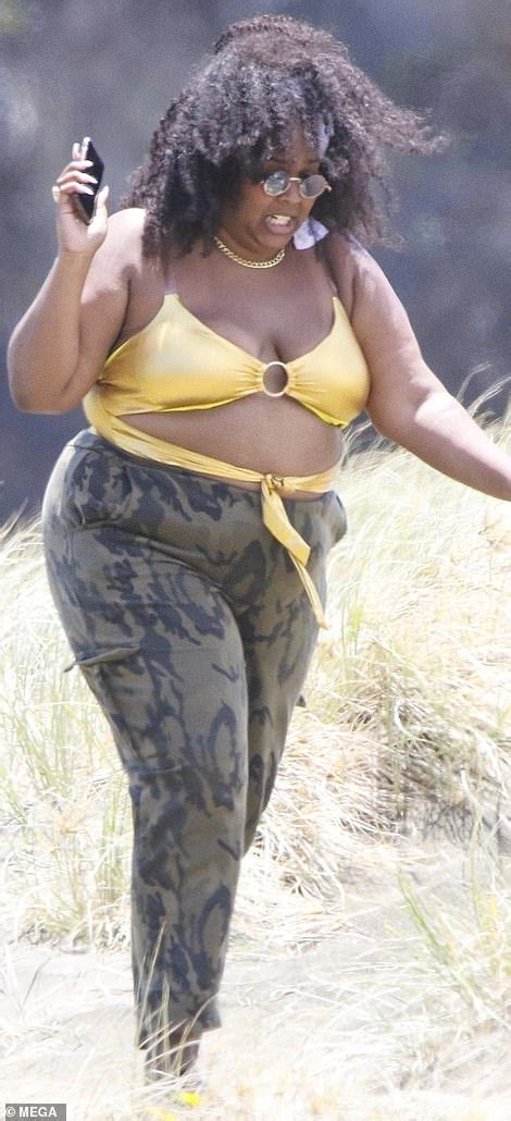 Lizzo flies the flag for body positivity as she hits the beach in gold swimsuit - ReadSector