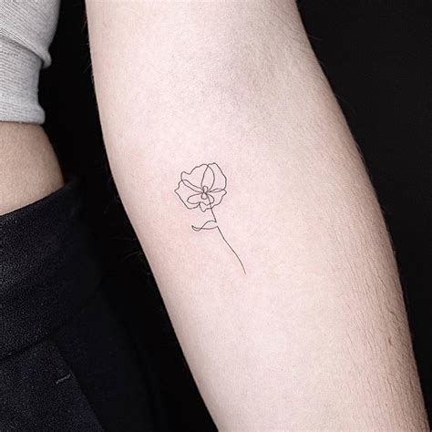 One line flower tattoo located on the inner forearm,