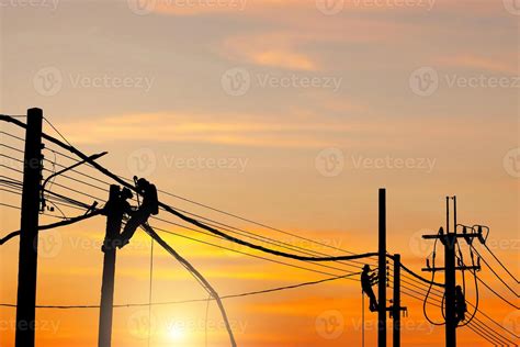 Silhouette of Electrician lineman worker at climbing work on the electric post power pole ...