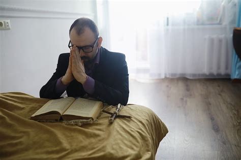 Premium Photo | Man reading and pray from the holy bible near the bed ...