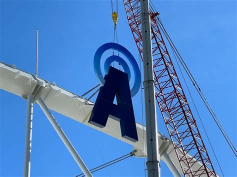 Workers begin installing JMA sign at JMA Wireless Dome