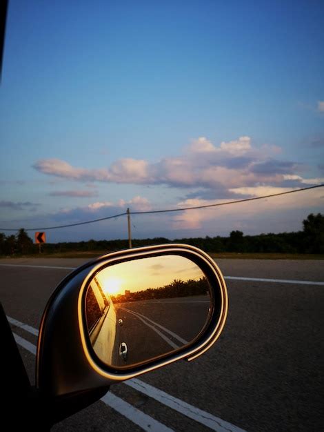 Premium Photo | Reflection of road in side-view mirror