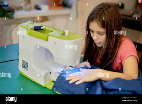 A young girl sews on a sewing machine at home.Lifestyle. Hobbies and hobbies, creativity ...