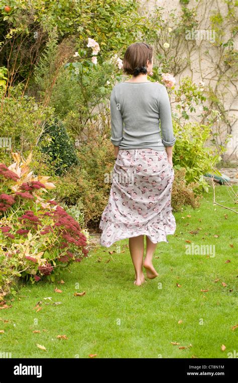 Back view of a teenage girl walking barefoot in her garden Stock Photo ...