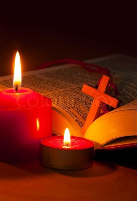 Open Bible with cross and burning red ... | Stock image | Colourbox