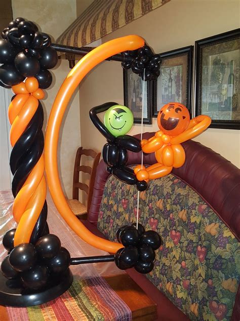 an orange and black balloon arch decorated with balloons