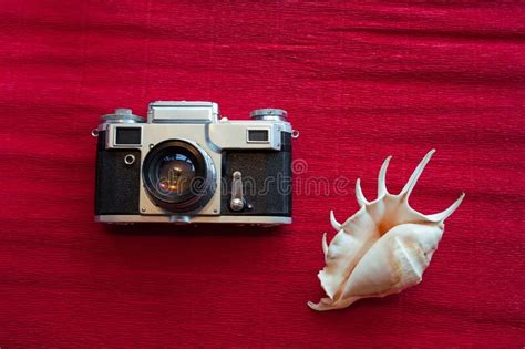 Old Soviet Film Camera and a Beautiful Sea Light Shell Lie on a Textured Red Paper Stock Photo ...