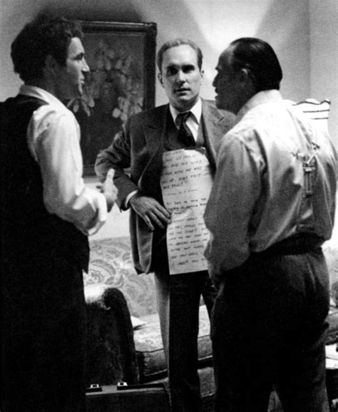 Robert Duvall holding Marlon Brando's lines on cue cards for a scene on the set of 'The ...