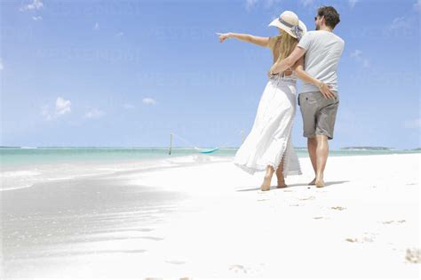 Happy couple on holiday, walking on a dream beach stock photo