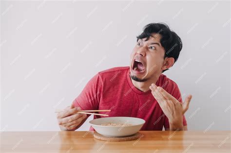 Premium Photo | Funny face of man eat very hot and spicy instant noodle