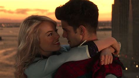 a man and woman embracing each other in front of a cityscape at sunset