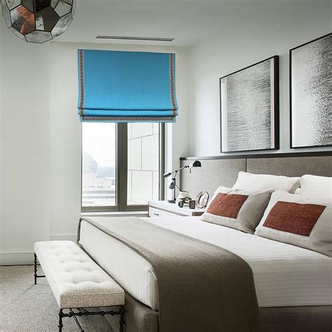 a bedroom with a large bed and blue roller shades