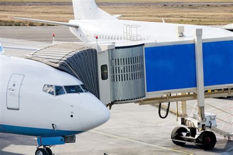 Premium Photo | Jetway is served to passenger airplane at airport.