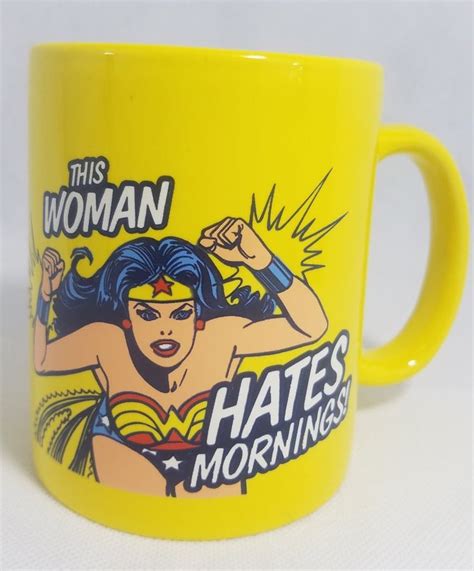 a yellow coffee mug with an image of wonder woman on it