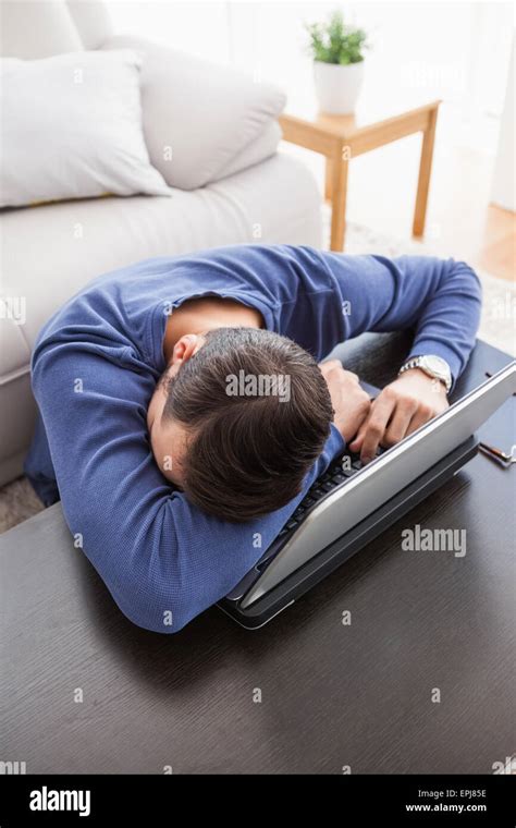 Young man sitting on floor using laptop Stock Photo - Alamy