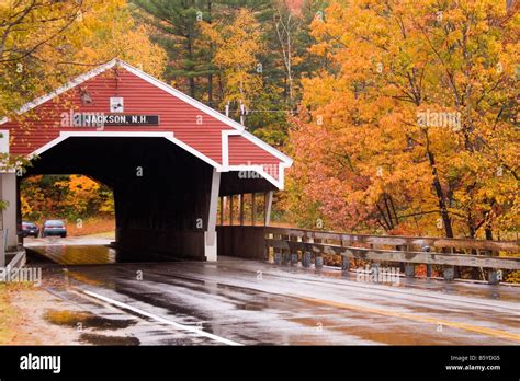 A covered bridge in Jackson, New Hampshire, surrounded by colorful ...