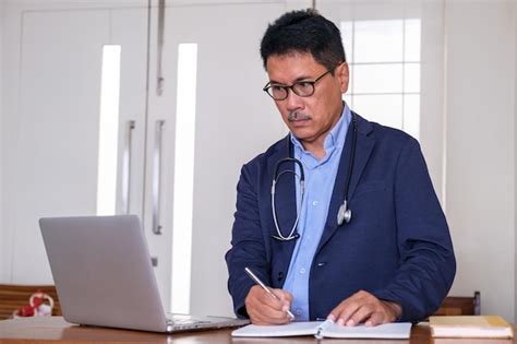 Premium Photo | A doctor sitting in front of laptop writing a medical ...