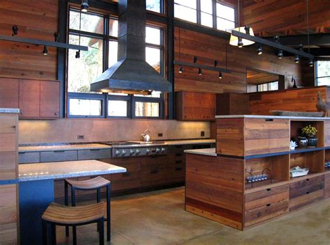 Salvaged cedar wood panels the kitchen walls in this modern cabin. Maple cabinetry complemen ...