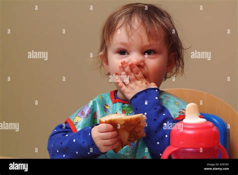Three year old girl eats pizza at kitchen table Stock Photo - Alamy