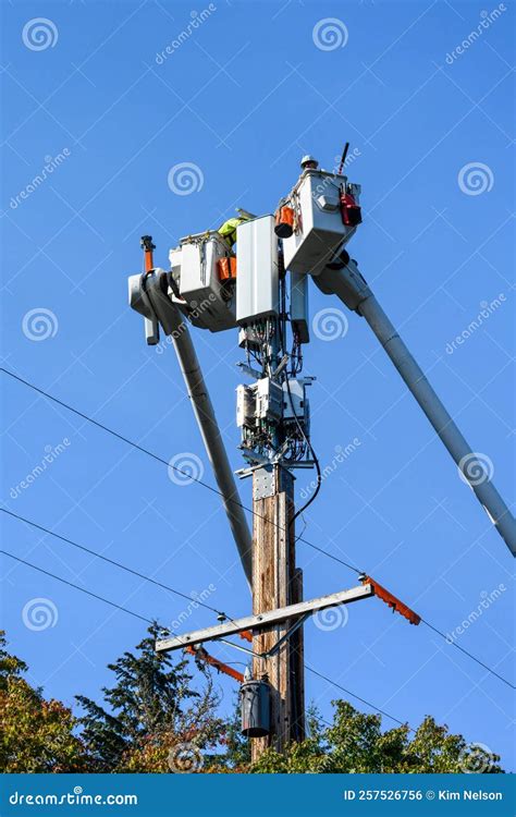 Two Linemen Working on a Wireless Communications Radio and Antenna Installation Using a Bucket ...