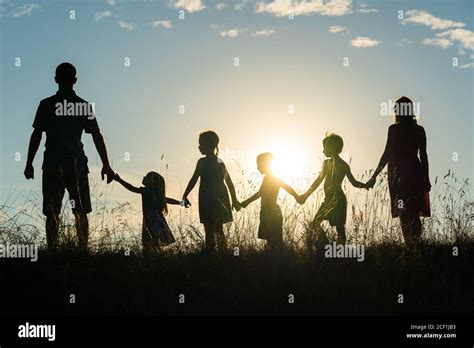 Silhouette of a happy large family at sunset Stock Photo - Alamy