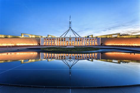 Dramatic evening sky over Parliament House, illuminated at twilight ...