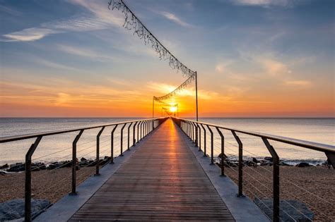 Premium Photo | Bridge on the beach at sunrise