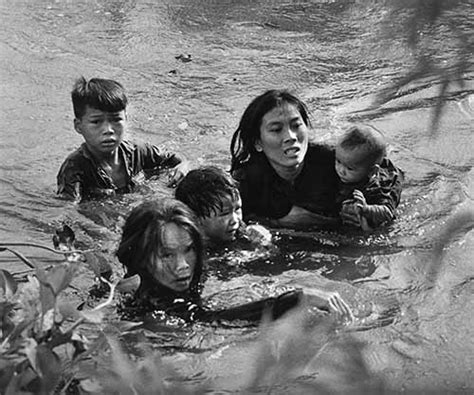 A mother and her children wade across a river to escape US bombing, 1965 - Rare Historical Photos