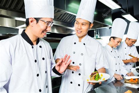 Asian Chef in restaurant kitchen cooking — Stock Photo © Kzenon #79329224