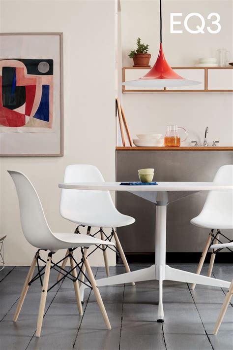 two white chairs sitting at a table in a room