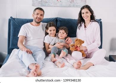 Cheerful Family Barefoot Sitting On Bed Stock Photo 1399348130 ...