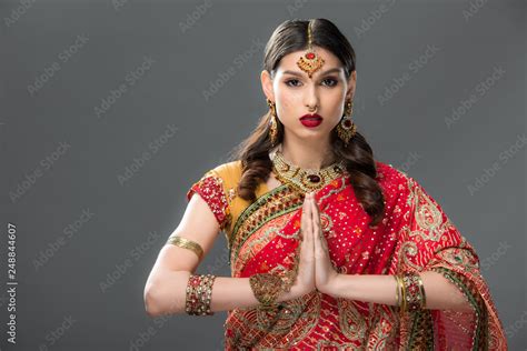 indian woman in traditional clothing and accessories with namaste mudra, isolated on grey Stock ...