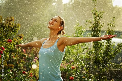 Portrait of a beautiful happy woman enjoying rain falling in her in a garden. Stock Photo ...