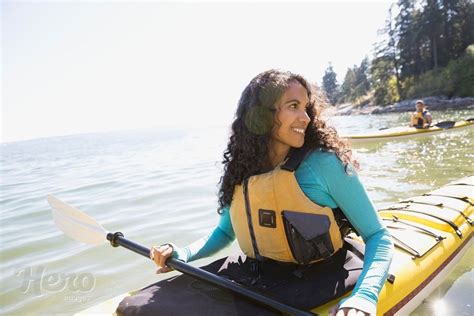 Smiling woman kayaking on sunny ocean | Sun protective clothing, Kayaking, Women