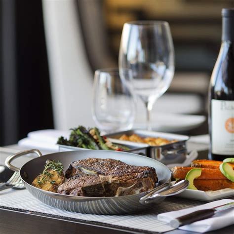 a table topped with plates and glasses filled with food next to wine ...