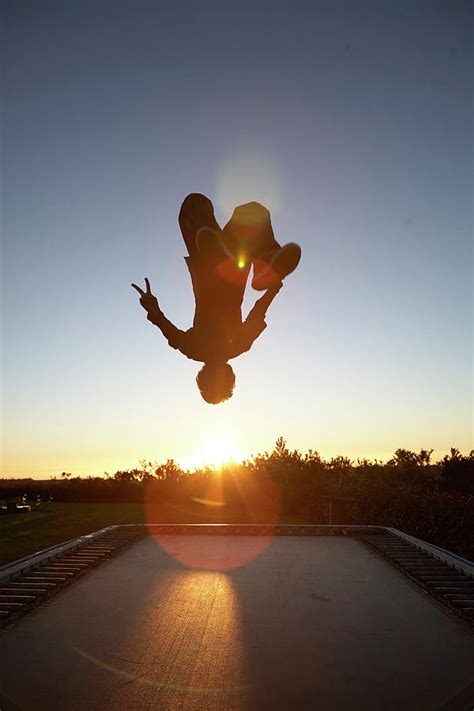 Man Doing Backflip On Trampoline Photograph by Ubald Rutar