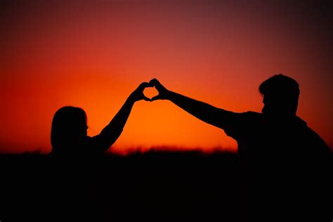 Silhouette of a Couple Making a Heart Shape with Their Hands · Free Stock Photo