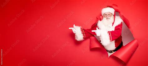 Santa Claus pointing on red empty background. Stock Photo | Adobe Stock