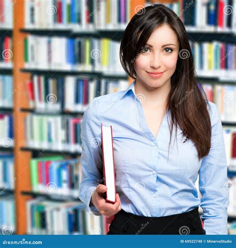 Smiling Teacher Holding a Book in a Library Stock Photo - Image of classroom, woman: 69522748