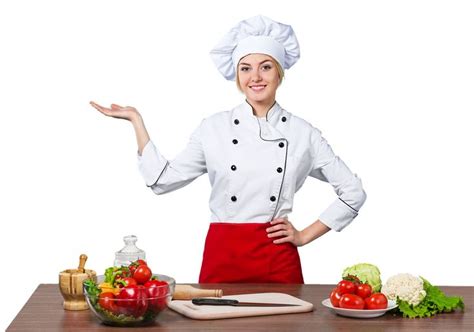 a woman in chef's outfit standing next to a table with vegetables