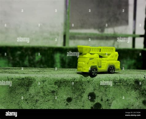 Yellow color fire truck toy presented on cemented surface for ...