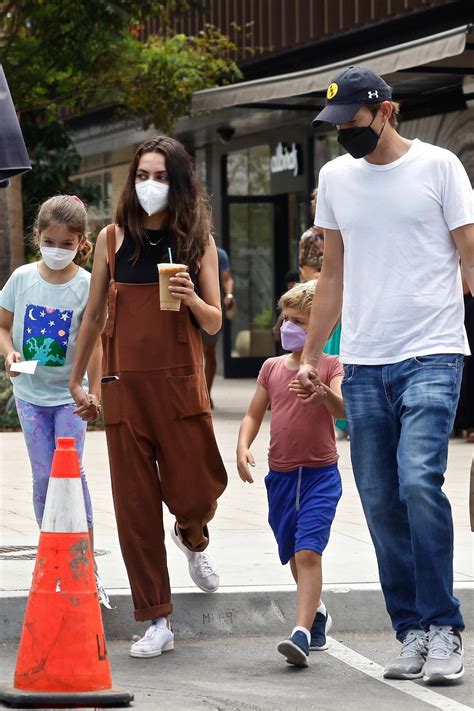 Mila Kunis and Ashton Kutcher walk hand in hand with their kids during a trip to Erewhon Market ...