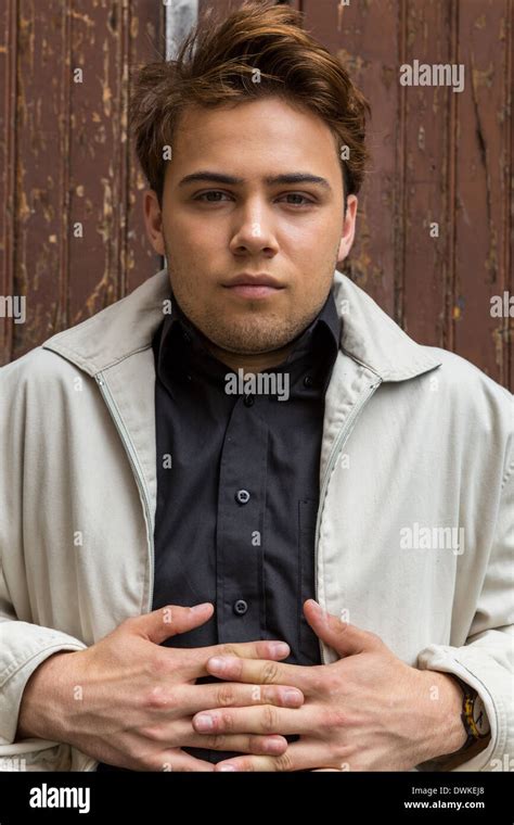 Handsome smirking young caucasian male sitting on a vintage industrial loading dock Stock Photo ...