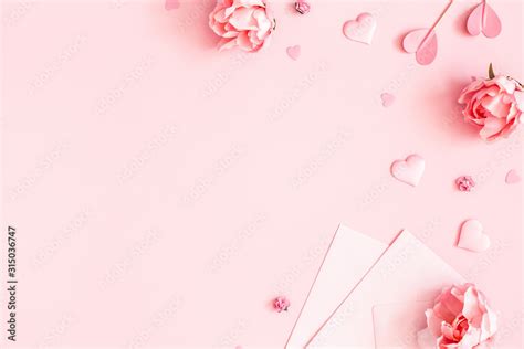 Valentine's Day background. Pink flowers, envelope, hearts on pastel pink background. Valentines ...