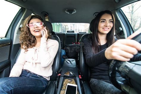 Two Young Girls Have Car Trip. Women Drive Car while Her Friends ...